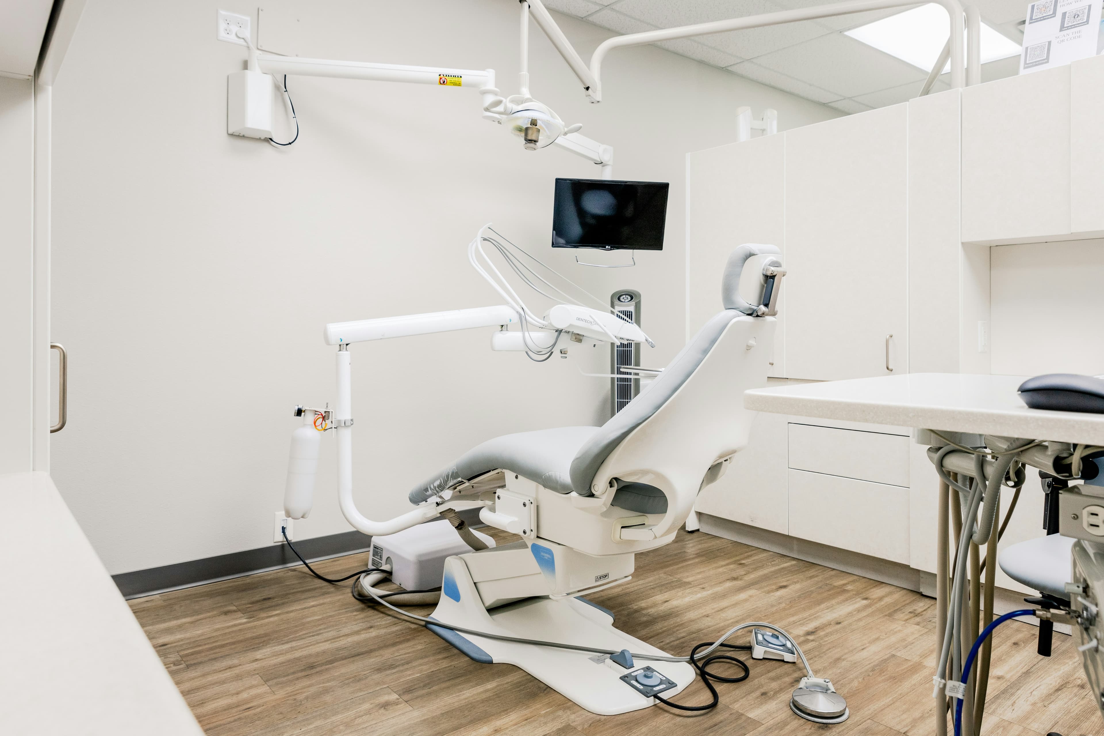 Clean modern dental operatory with grey treatment chair and cabinetry